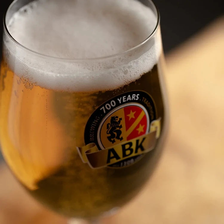 A close up shot of abk edel with the brewery logo prominent