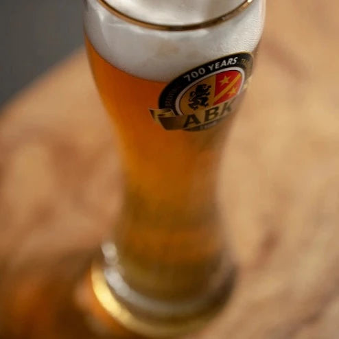 A close up of eibsee glass with beer in it on a wooden table