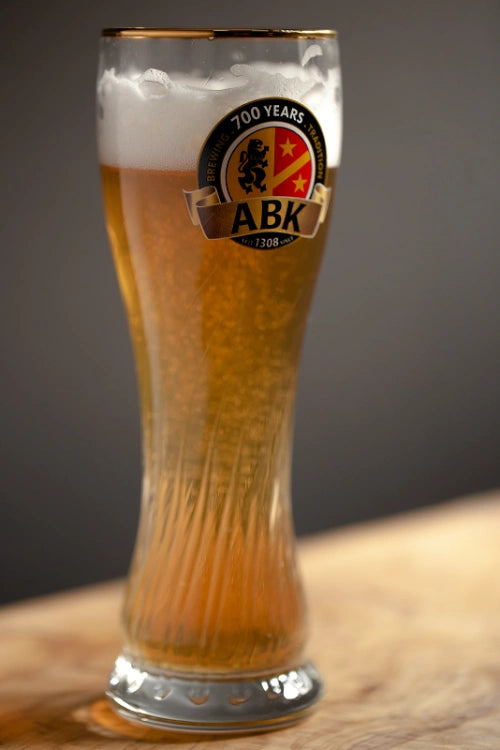 A tall eibsee glass with wheat beer in it