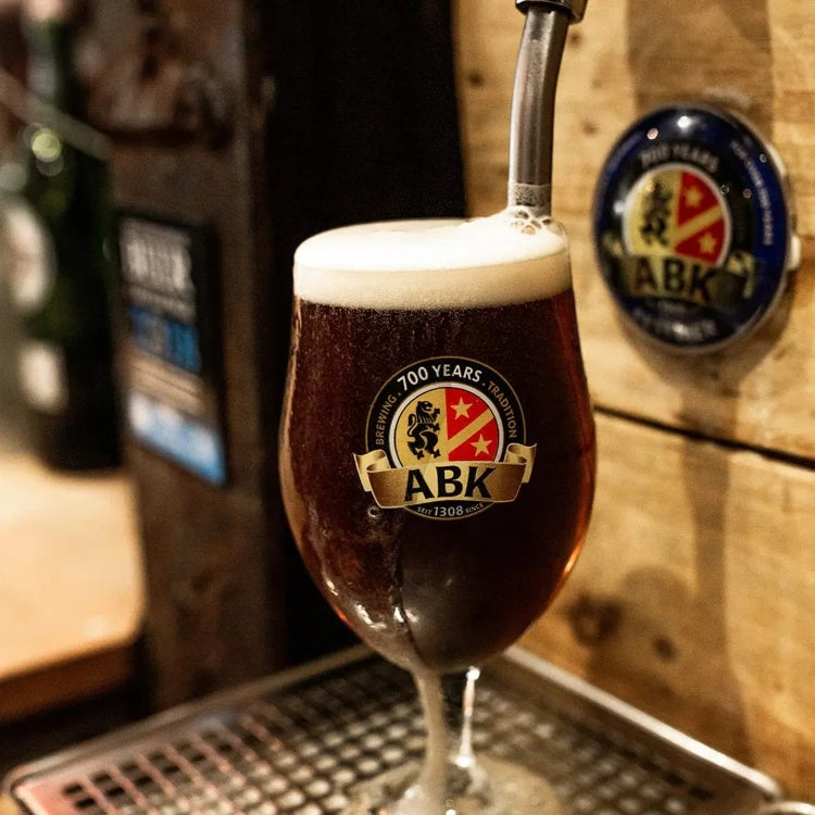 A pint of ABK Dunkel being filled on draught and overflowing