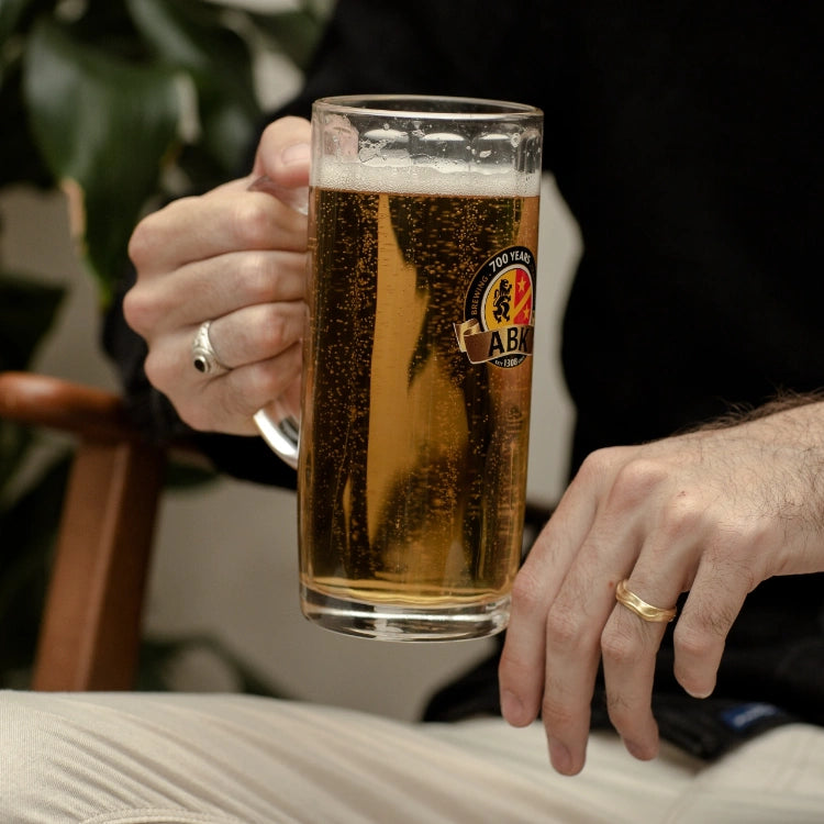A man holding a german tankard with ABK beer in it