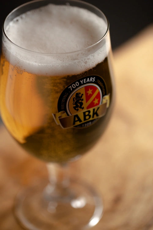 A close up of a A german munique glass with mouthwatering ABK